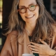 Woman smiling while putting left hand to chest