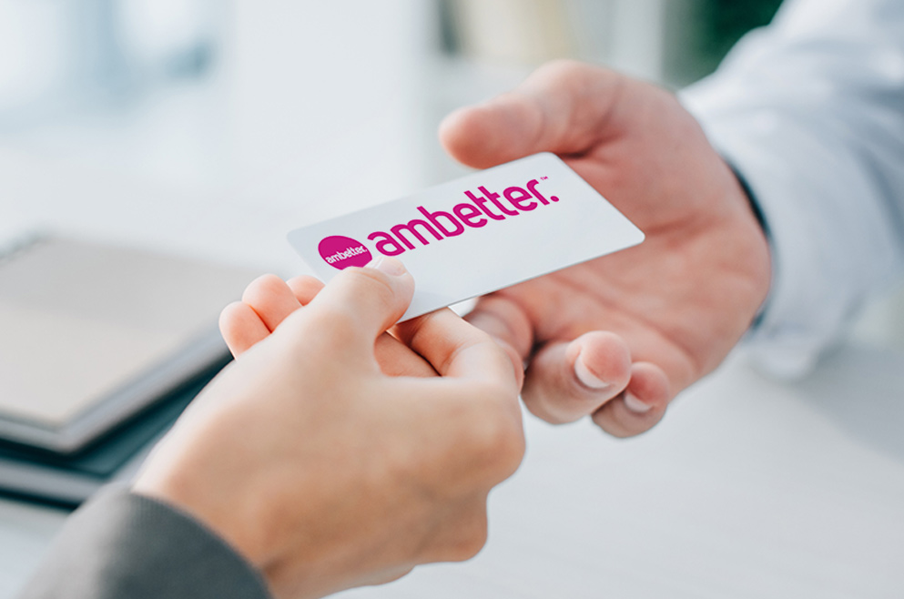 Photo of doctor handing a patient Ambetter card.