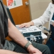 Dr. Hebert holding ultrasound trasnducer while patient sits on examination table