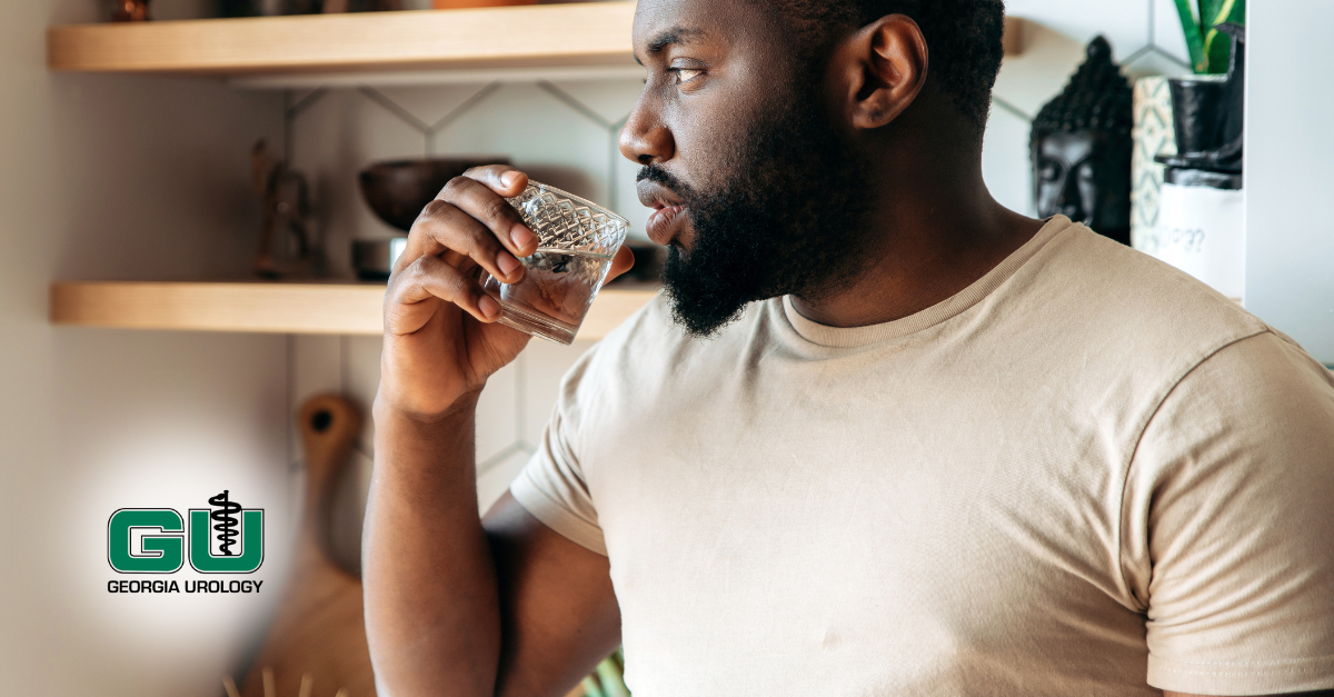 Man drinking water from glass in kitchen