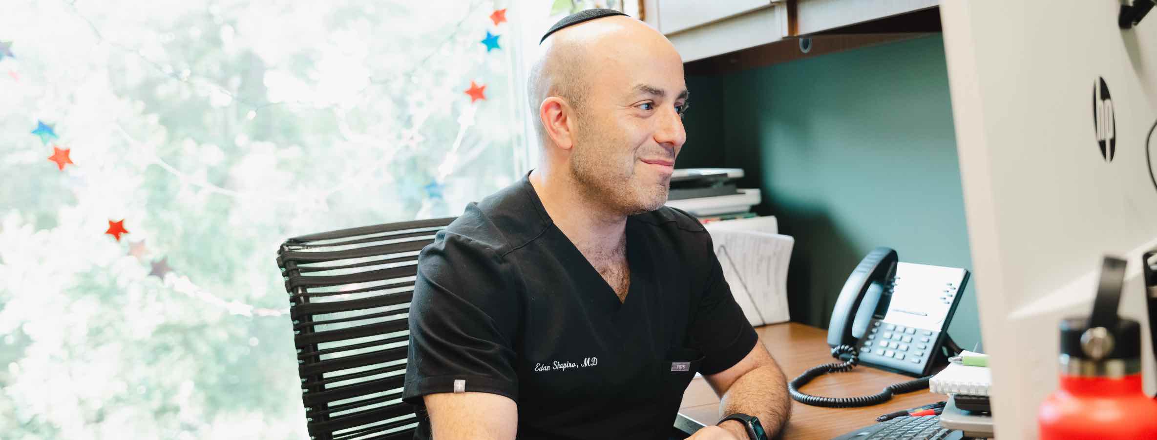 Dr. Edan Shapiro at his computer - telemedicine