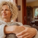 Woman sitting with knees to chest holding knees with both hands and looking to the side