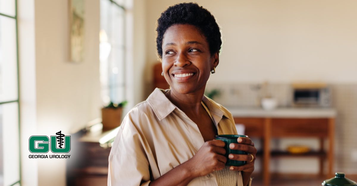 Woman smiling while looking outside window holding coffee with both hands