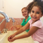 Two children at Montessori School Washing Hands In Washroom