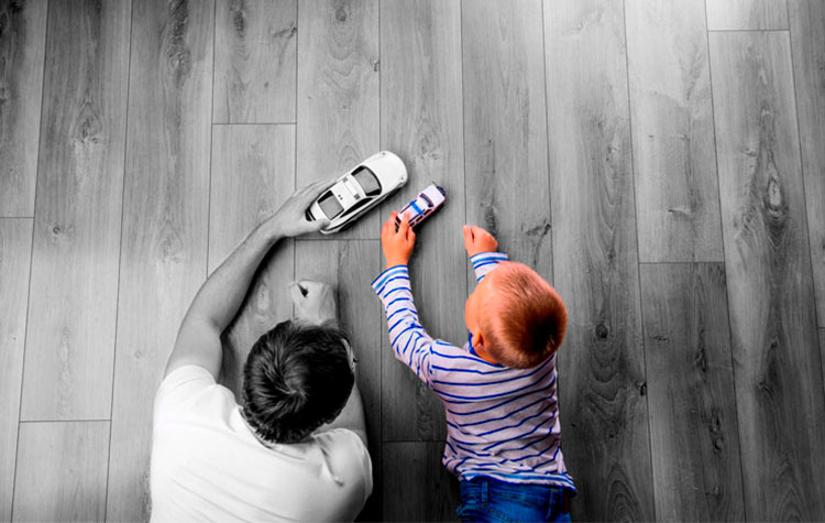 Father and son playing with toy cars on floor